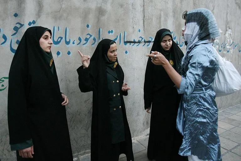 Иранская женщина-полицейский отчитывают прохожую за неправильную одежду