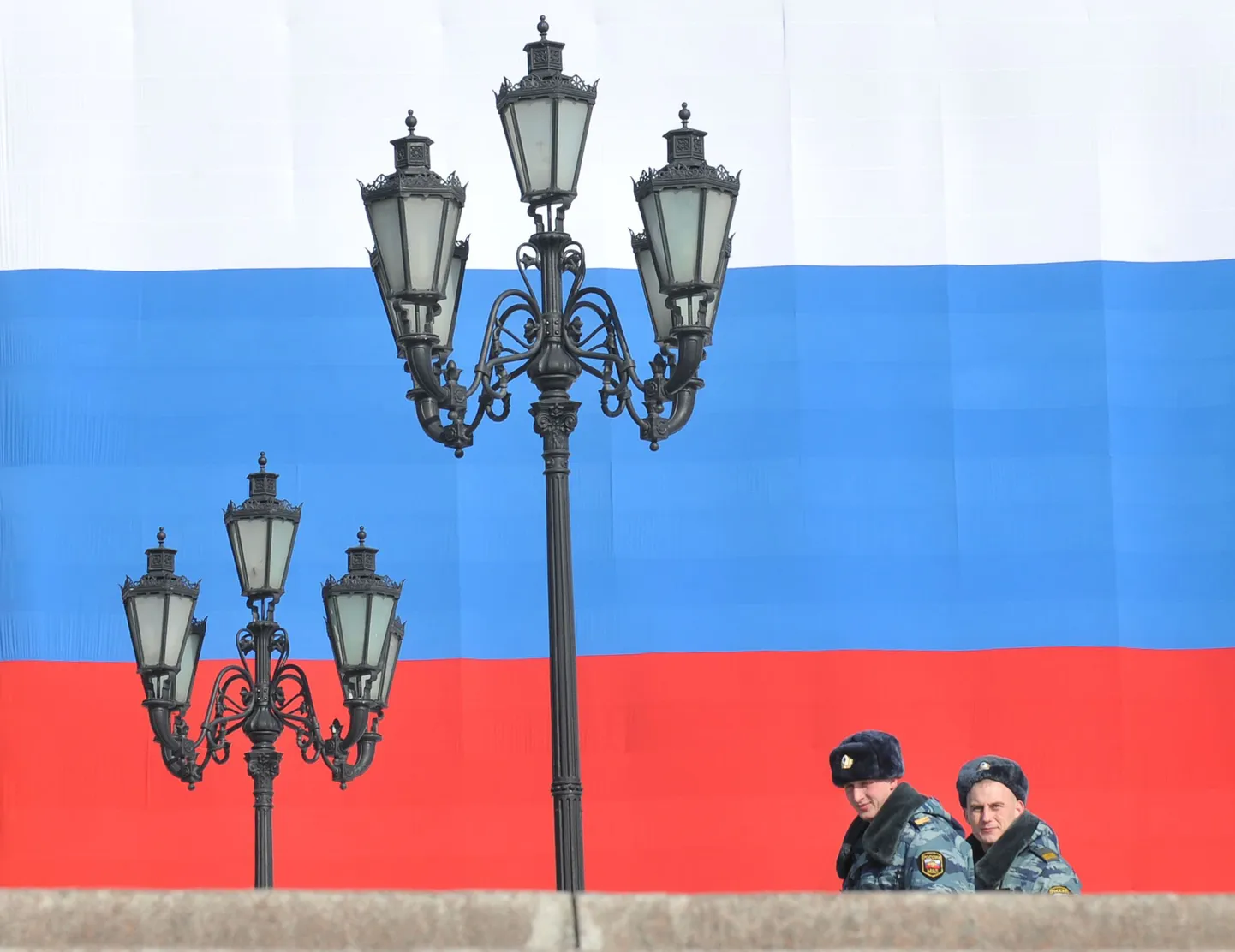 Politseinikud hiiglasliku Vene lipu taustal.