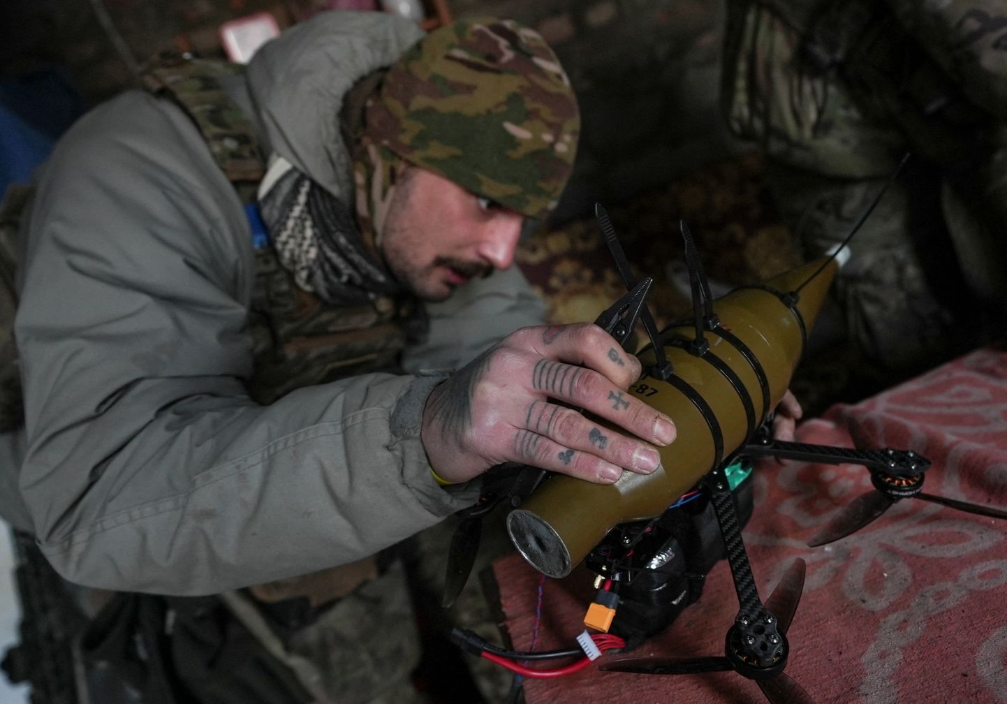 Украинский военнослужащий эскадрильи БПЛА «Рарог» 24-й отдельной механизированной бригады крепит снаряд от гранатомета РПГ-7 к беспилотнику недалеко от города Горловка, Донецкая область, Украина, 17 января 2024 года.
