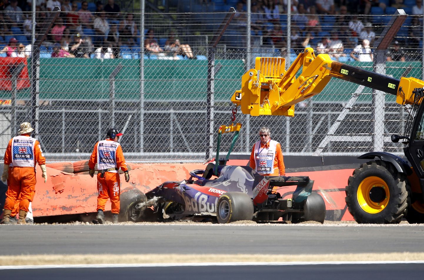 Brendon Hartley's Toro Rosso car is removed from the track after crashing out during third free practice at the Silverstone racetrack, Silverstone, England, Saturday, July 7, 2018. The British Formula One Grand Prix will be held on Sunday.(Martin Rickett/PA via AP)