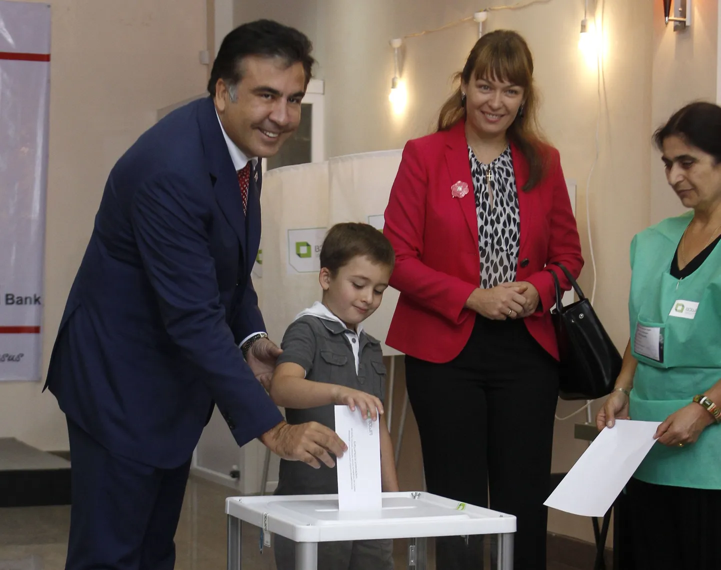 Gruusia president Mihheil Saakašvili (vasakult) koos abikaasa Sandra Roelofsi ja poja Nikolozega hääletamas.