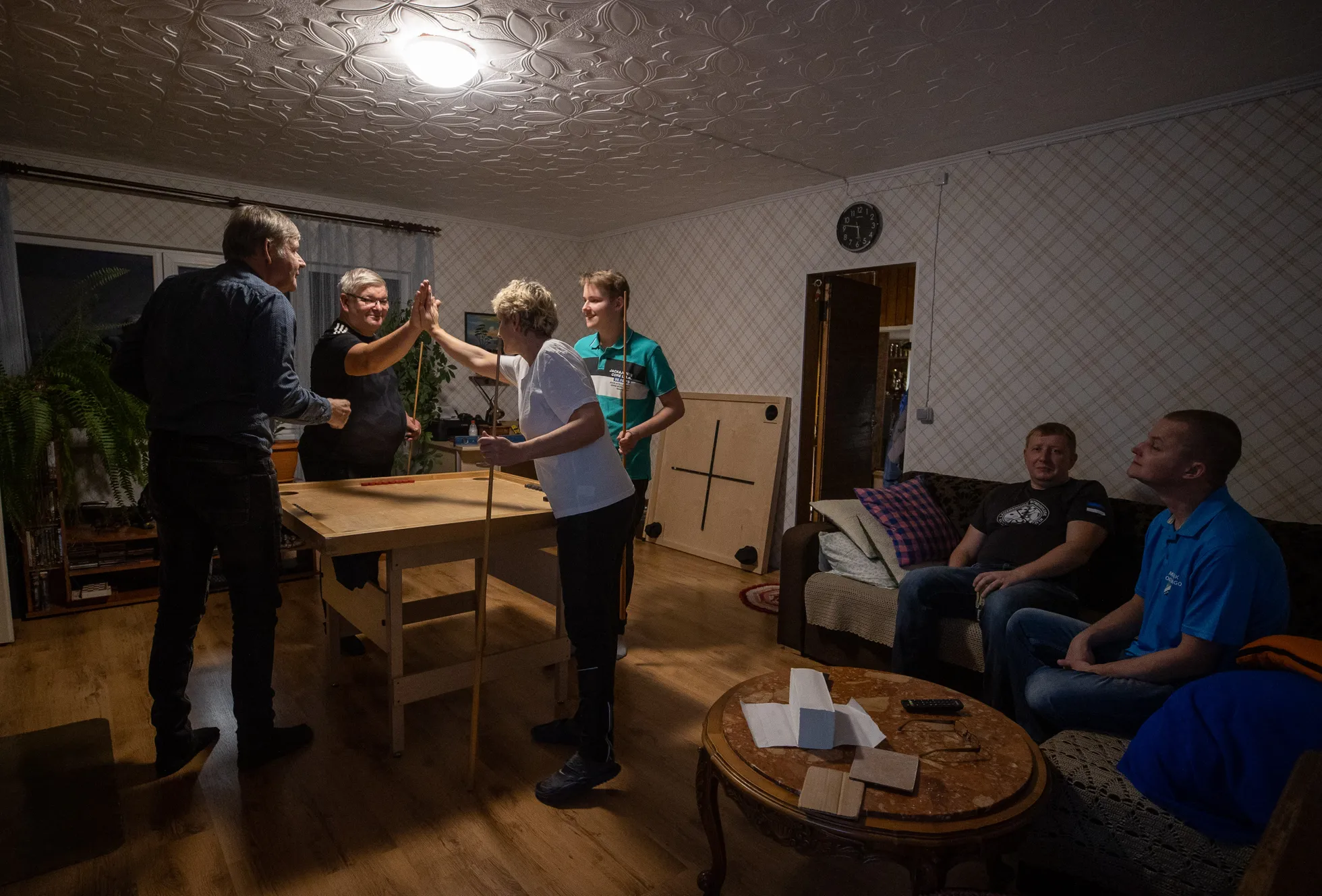 Läheb mänguks! Võõrustaja Hillar Elva (prillidega) on paaris Eesti koroonamängu tippu kuuluva ja 2003. aastal Euroopa meistriks tulnud Andrea Uustulndiga (valges), vastasteks Andrea mees, samuti Eesti tippmängija, Mihkel Lepist (vasakul) koos nende poja Marek Lepistiga (laua ääres paremal).