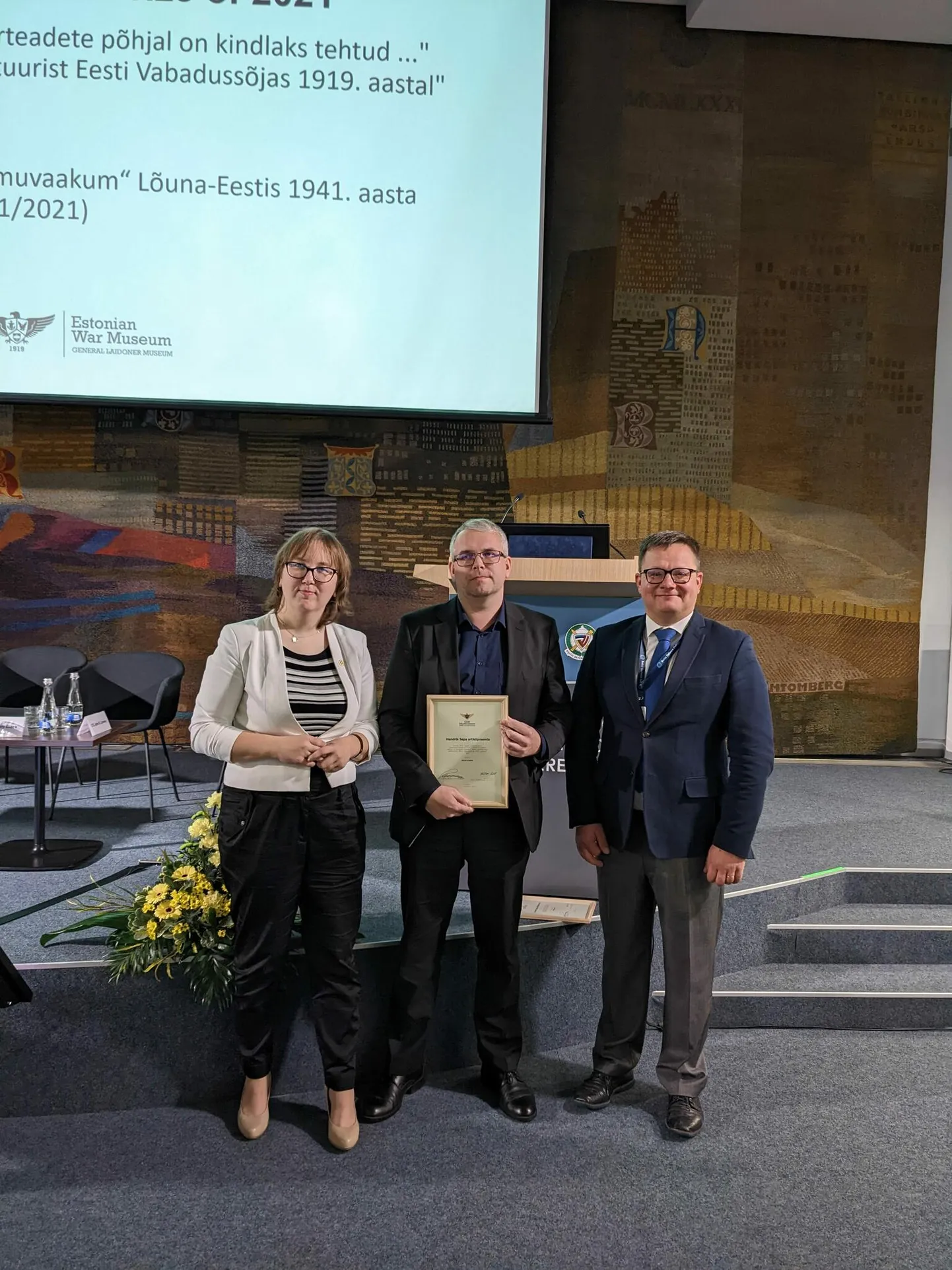 Artiklipreemia üks laureaat on Otepäält pärit Toivo Kikkas (keskel). Paremal hindamiskomisjoni liige, sõjamuuseumi vanemteadur Mari-Leen Tammela, vasakul Eesti sõjamuuseumi direktor Hellar Lill.