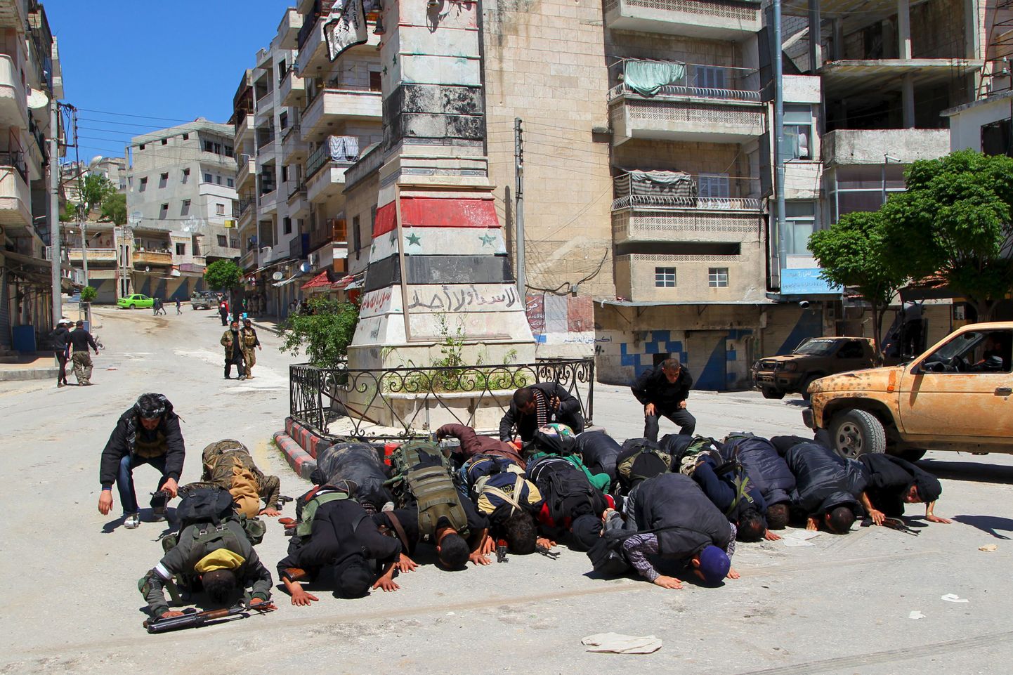 Valitsusvastased võitlejad Jisr al-Shughuris tänaval palvetamas pärast linna hõivamist 25. aprillil