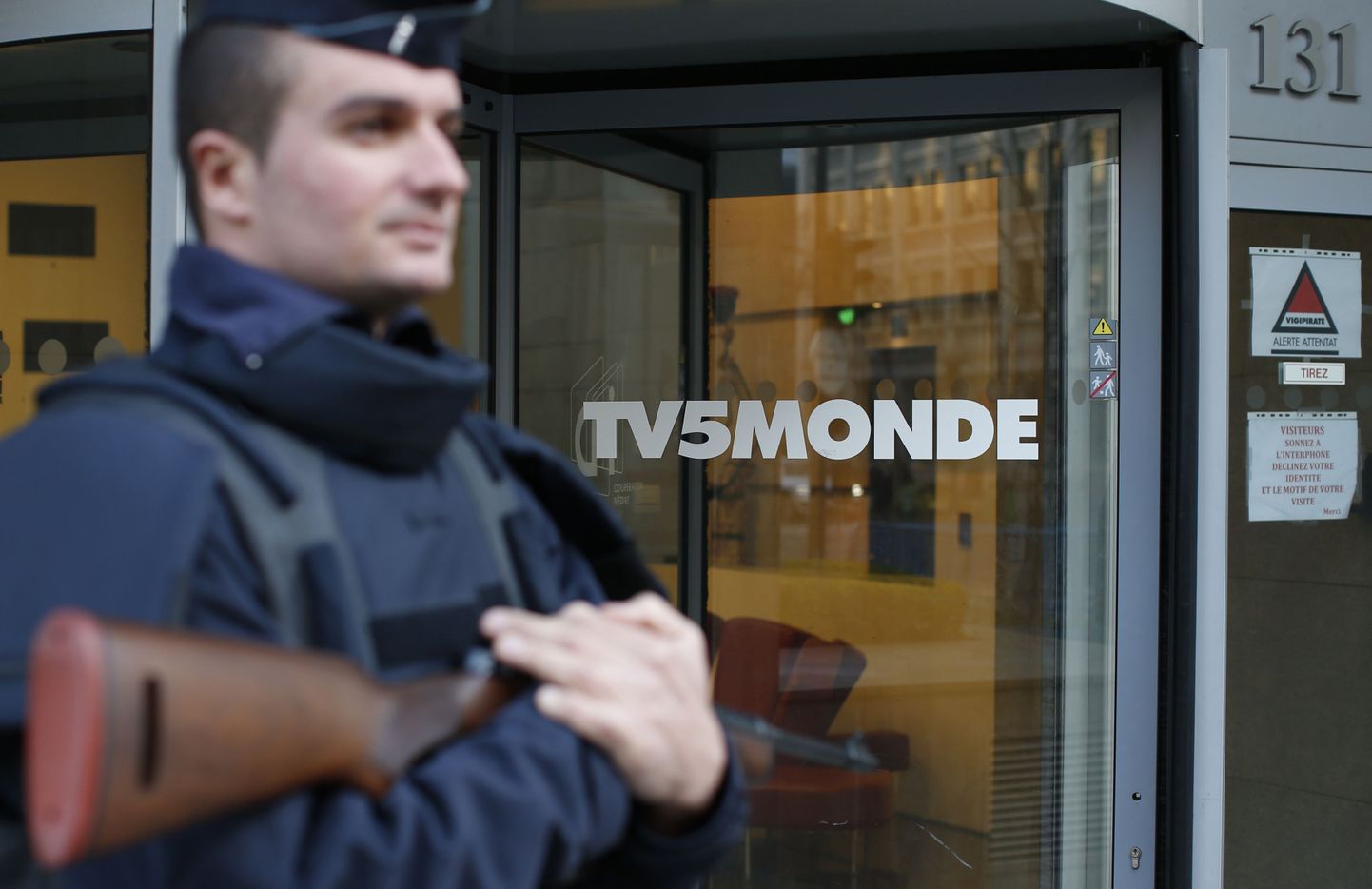 Prantsuse politseinik valvamas telejaama TV5Monde peakorteri sissepääsu.