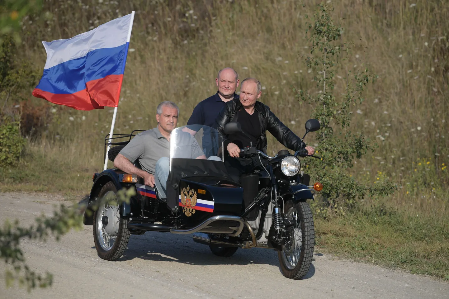 Сергей Аксенов (в коляске) и Владимирр Путин (за рулем) катаются на мотоцикле по Крыму, 2019 год.