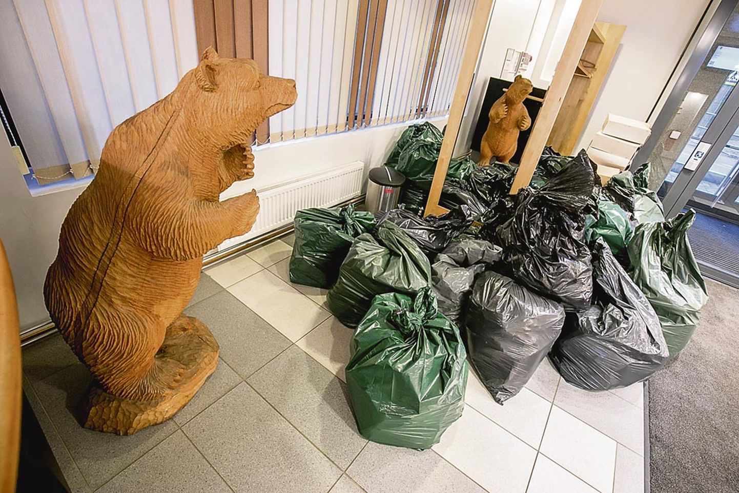 Tammepuust voolitud karu kui Pärnu maakonna vapiloom jälgis fuajees tummalt dokumente täis kilekottide kuhjumist.