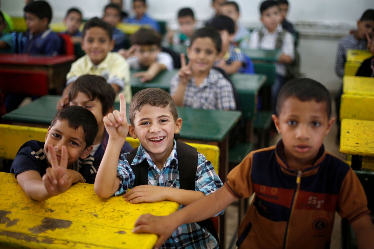 Refugee schoolchildren react to the camera as they attend a lesson in a classroom on the first day of the new school year at one of the UNRWA schools at a Palestinian refugee camp al Wehdat, in Amman, Jordan, September 1, 2016.  REUTERS/Muhammad Hamed