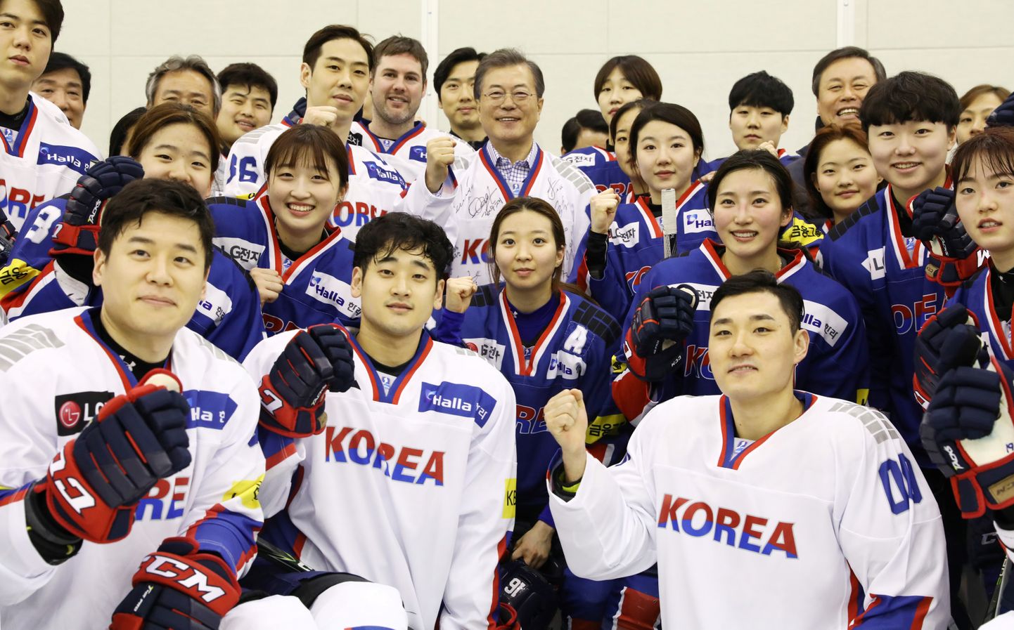 Lõuna-Korea president Moon Jae-in (keskel) poseerib koos riigi meeste ja naiste hokikoondisega.