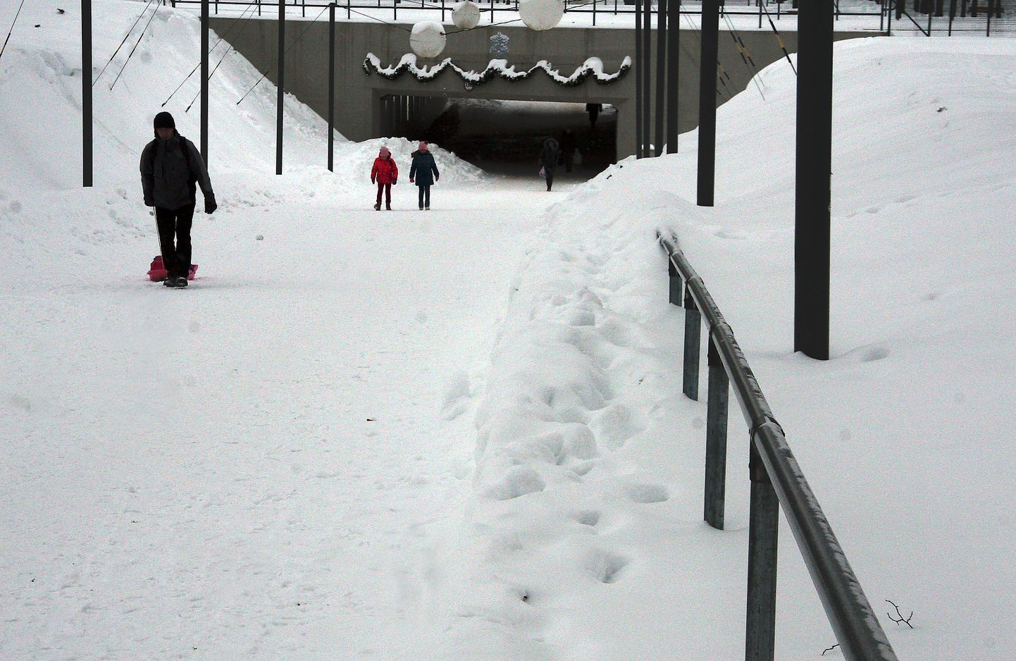 У расположенного на променаде пешеходного туннеля пешеходные дорожки расчищены так, что перила местами тонут в снегу и снежный вал мешает пользоваться ими.