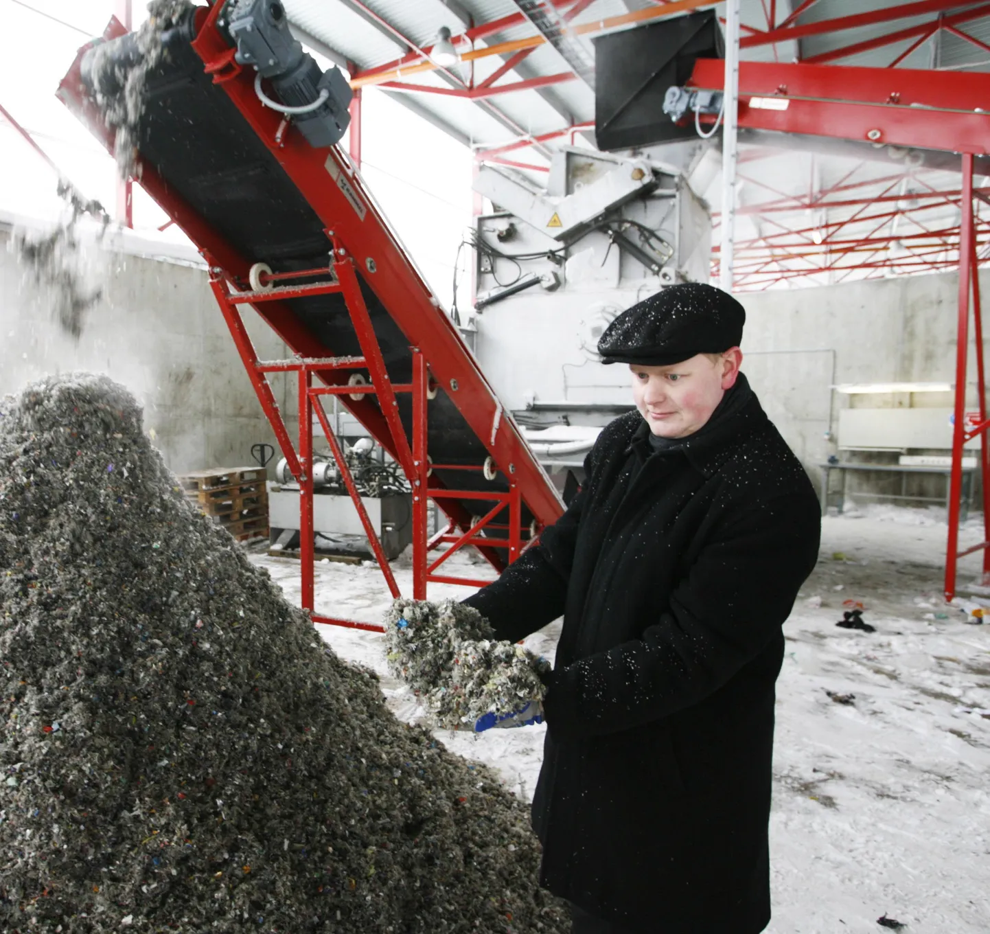 Tallinna Prügila juhatuse liige Allan Pohlak näitab tootmisliinil valminud kõige peenema fraktsiooniga kütust, mida märtsis hakatakse Lätti müüma.