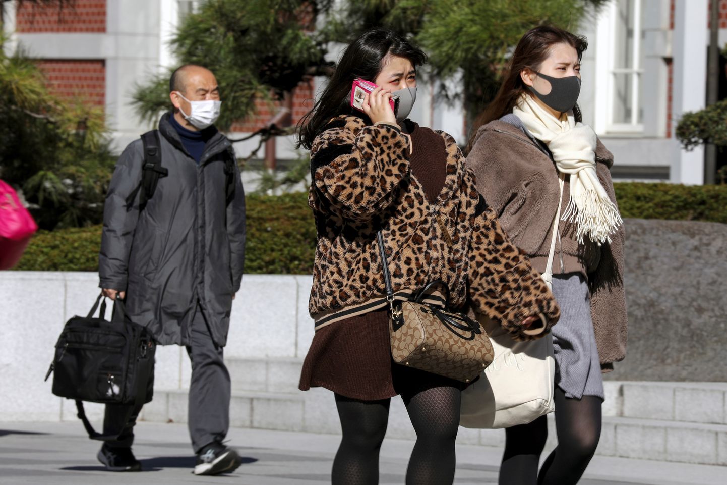 Cilvēki sejas maskās Tokijā.