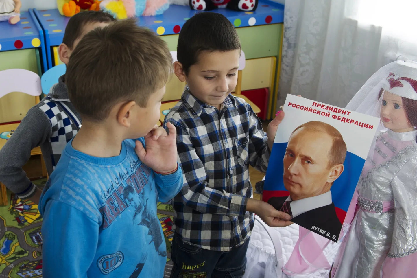 Vladimir Putini portreega lasteaialapsed.