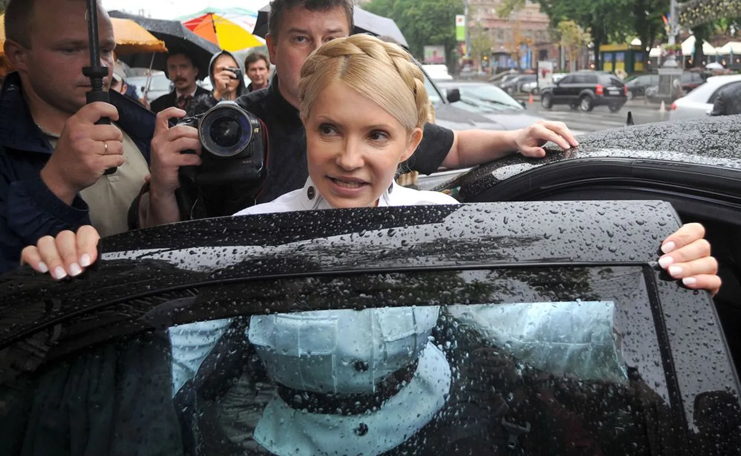 Юлия Тимошенко в окружении своих сторонников садится в машину после судебного заседания накануне своего ареста