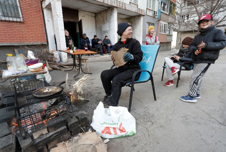 Ukraina Mariupoli elanik, 34-aastane Jekaterina Lanina tegemas oma kahele lapsele ja naabritele nende kortermaja juures süüa