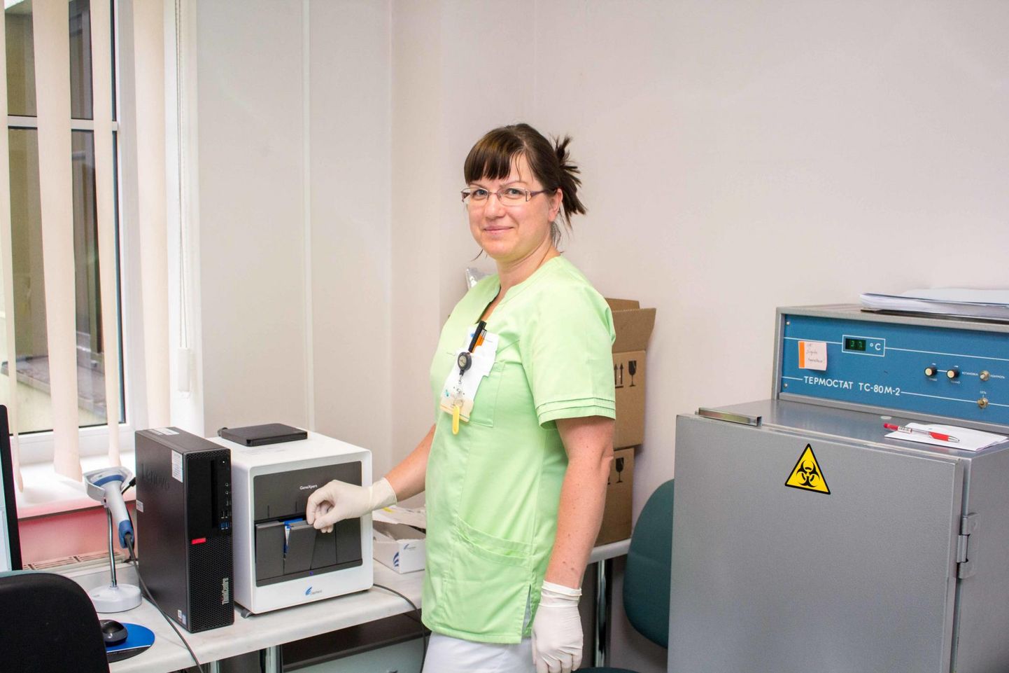 Valga haigla bioanalüütik Liisi Võsu demonstreerib koroonaviiruse proovide analüüsiaparaati, mis suudab ühes tunnis analüüsida kaht testi.