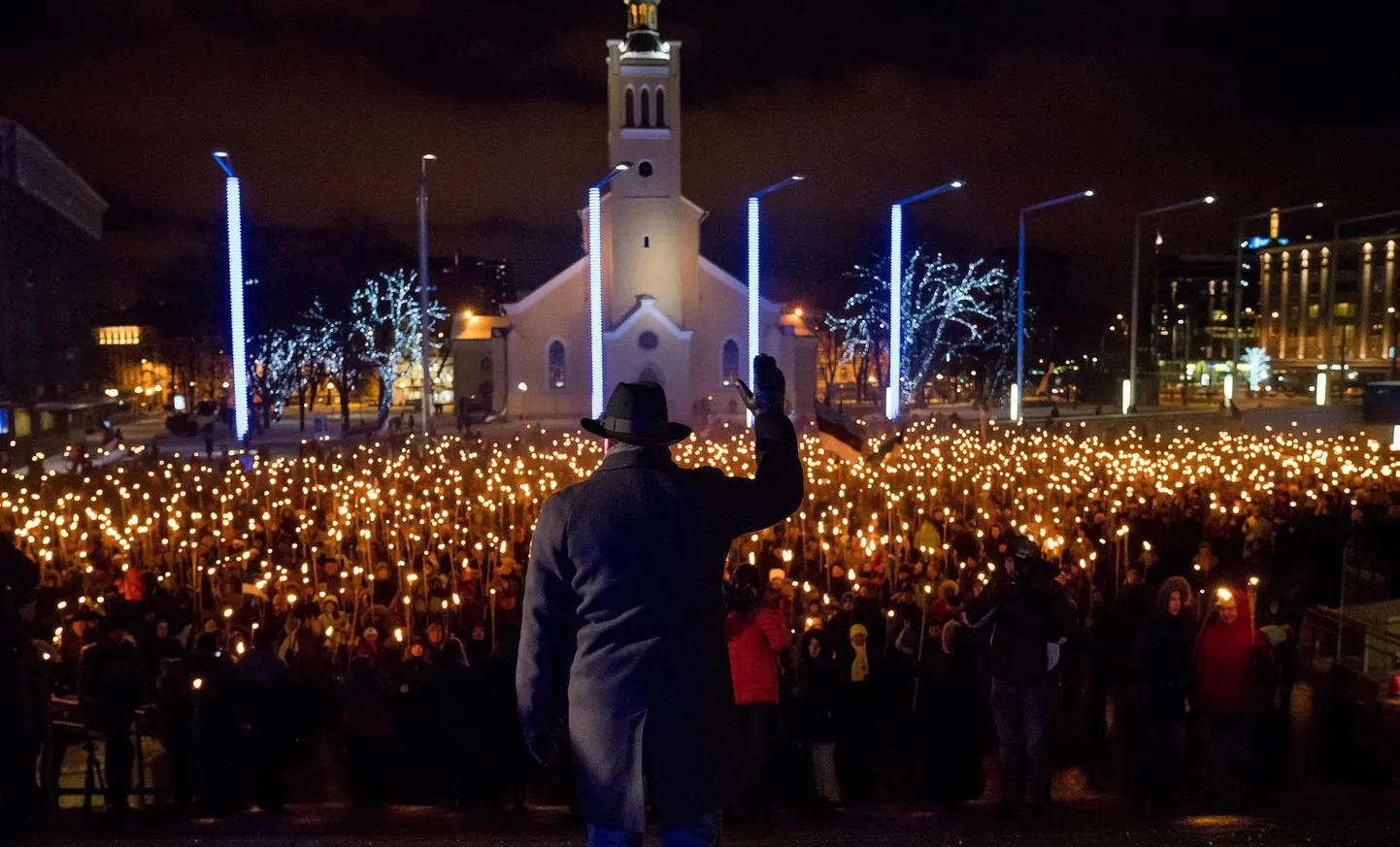 Лидер EKRE Март Хельме приветствует народ, собравшийся на факельное шествие.