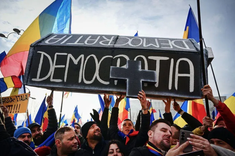 Люди несут гроб с надписью «Демократия» на румынском языке.