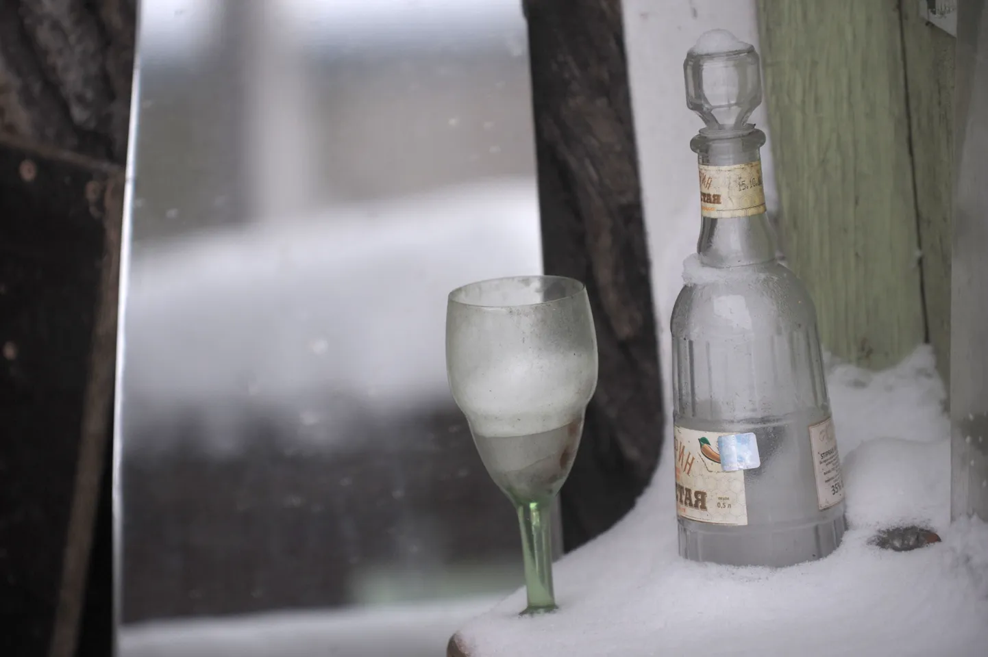 Pudele un glāze sniegā; ilustratīvs foto.