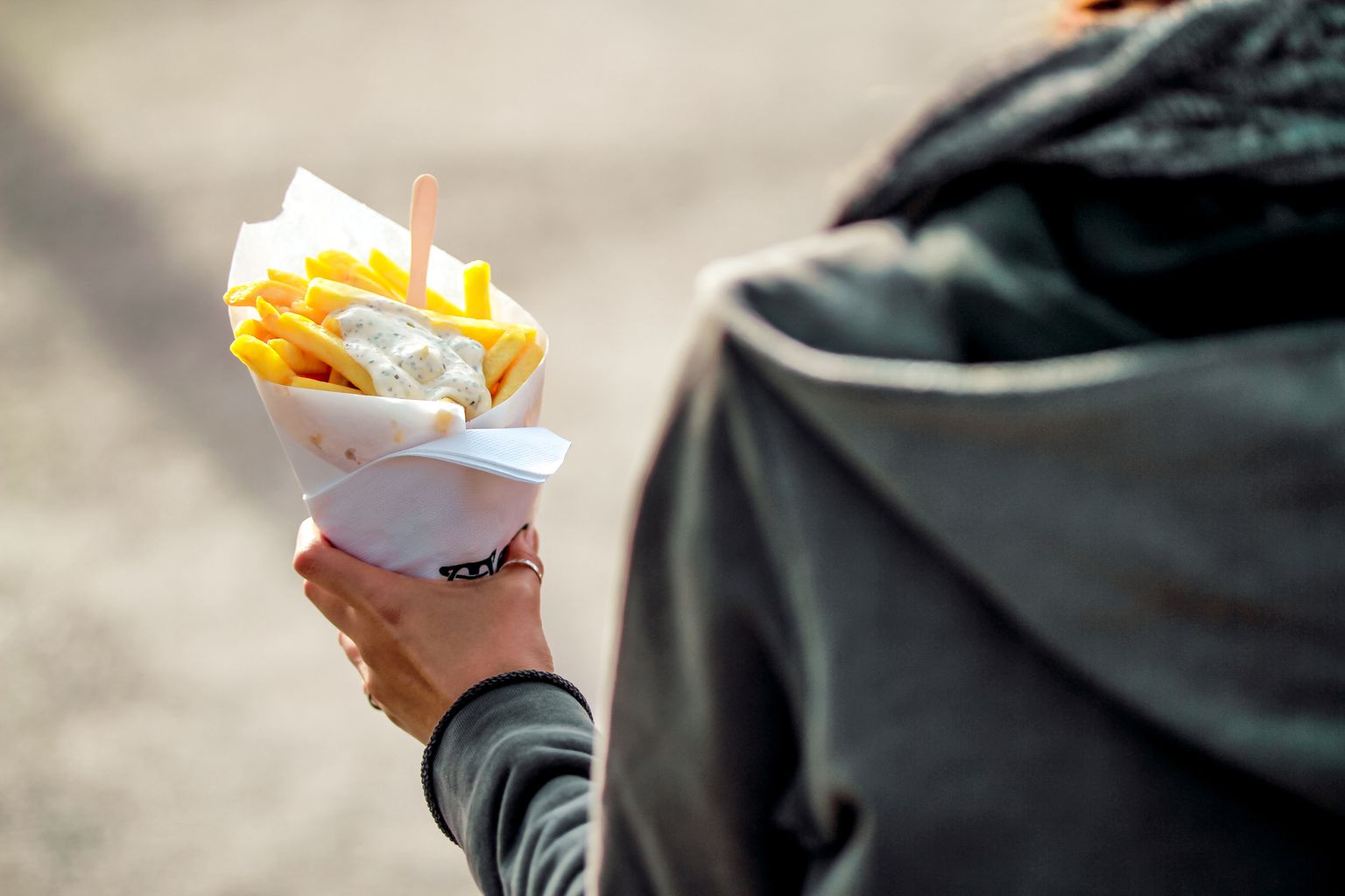 Inimene hoidmas Belgias Brüsselis tuutut friikartulite ja majoneesiga. Pilt on illustreeriv