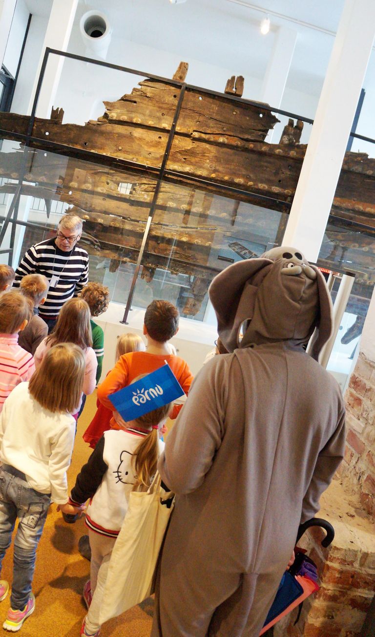 Pillerpalli lapsed muuseumihiirega kohalikus muuseumis 1990. aastal Pärnu jõest leitud koge uudistamas.