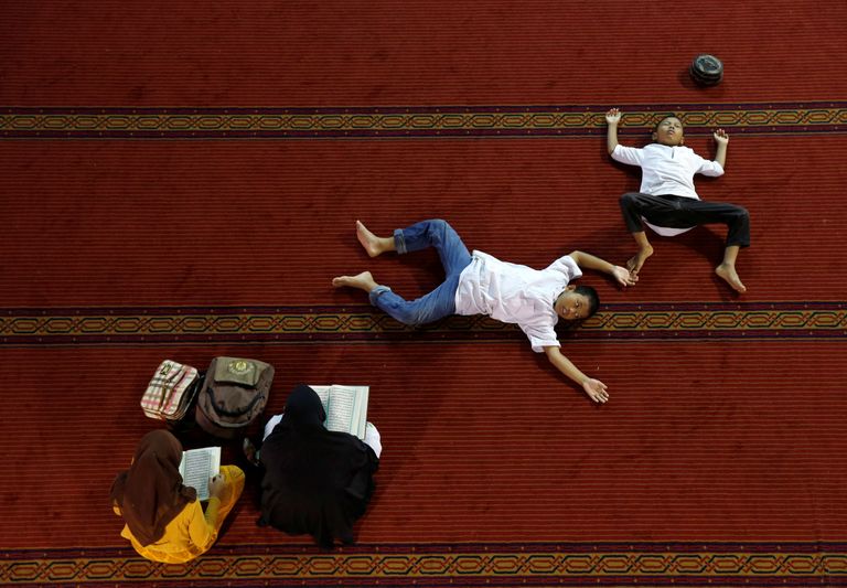 Indoneesia. Naised loevad ramadani ajal Jakarta Istiqlali mošees koraani, sellal kui nende lapsed puhkavad. 