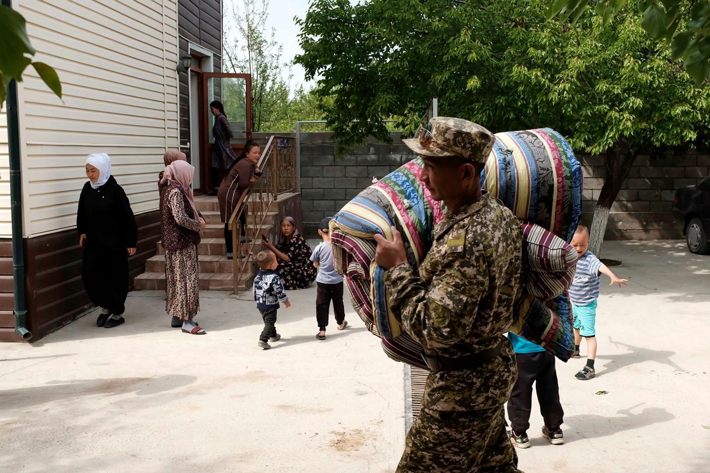 Kõrgõzstani sõjaväelane kandmas madratseid evakueeritud elanikele.
