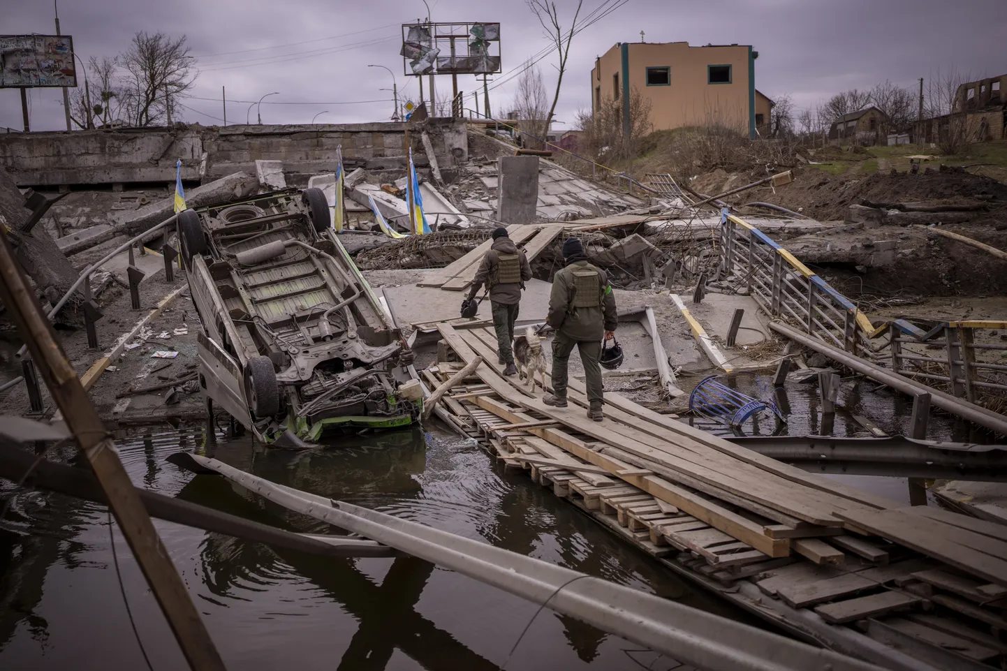 Украинские солдаты идут по разрушенному мосту в Ирпене