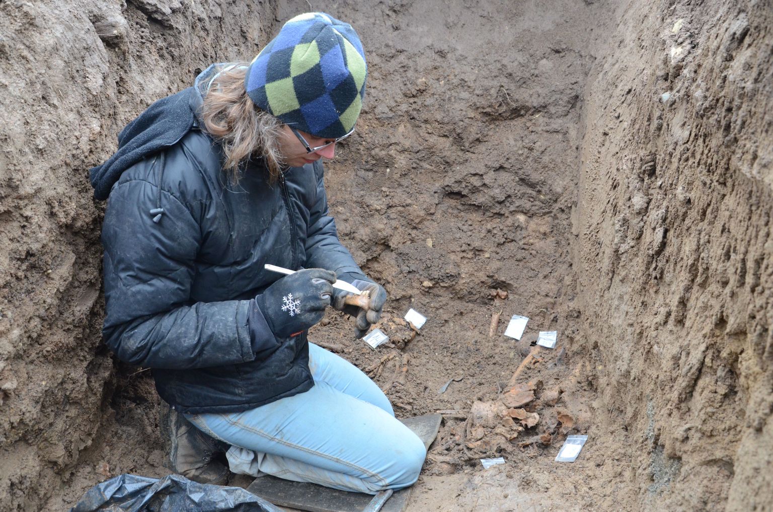 Tartu ülikooli osteoloog Martin Malve puhastab ühishauda maetud lapse alalõualuu fragmenti.