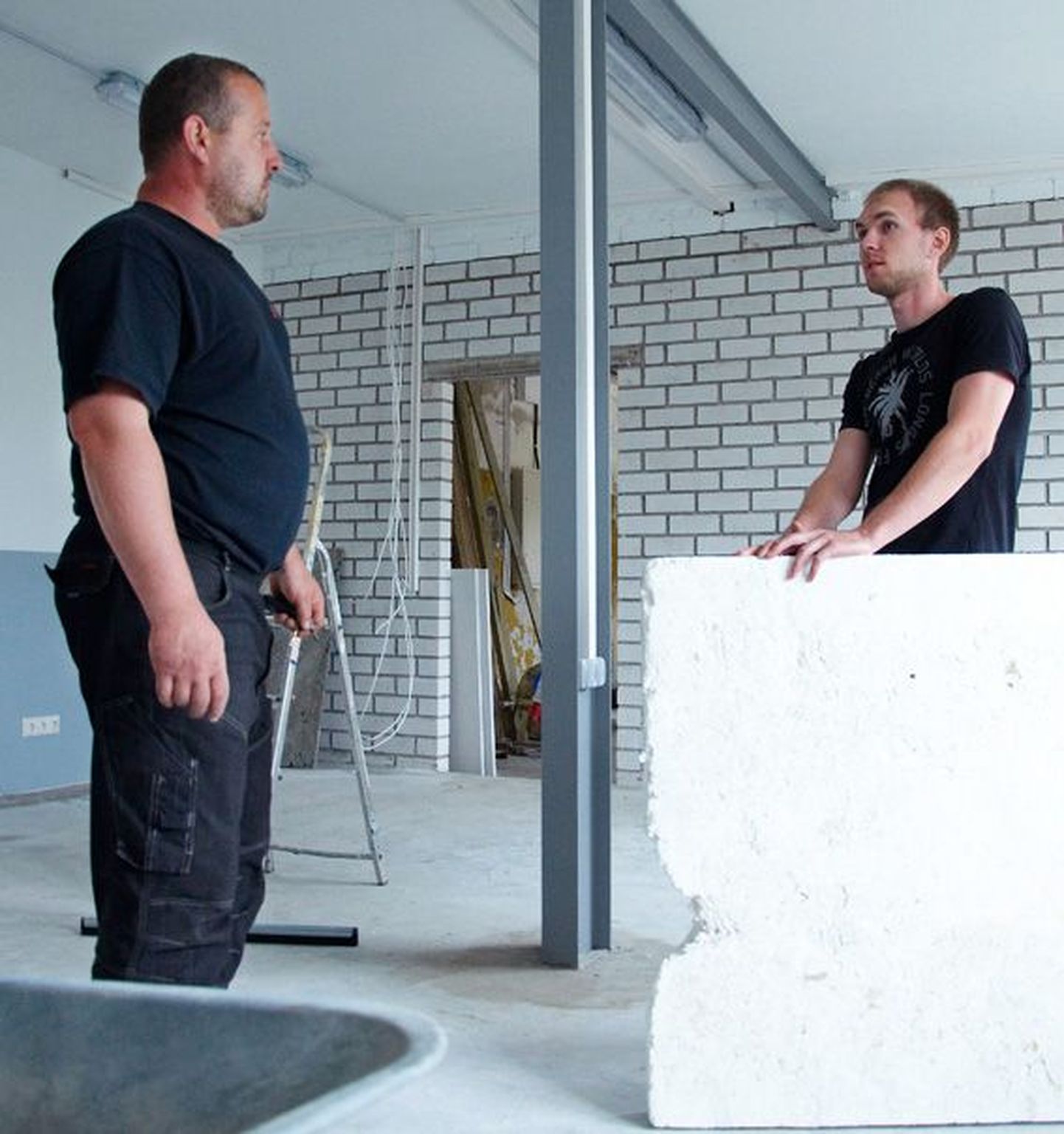 Ettevõtja Erko Jullinen (paremal) ja ehitaja Jaanus Tiinast tööstusküla renoveerimisjärgus hoones, kus on plaanis alustada täispuidust ripplagede ja alumiiniumist hooldusluukide tootmist.
