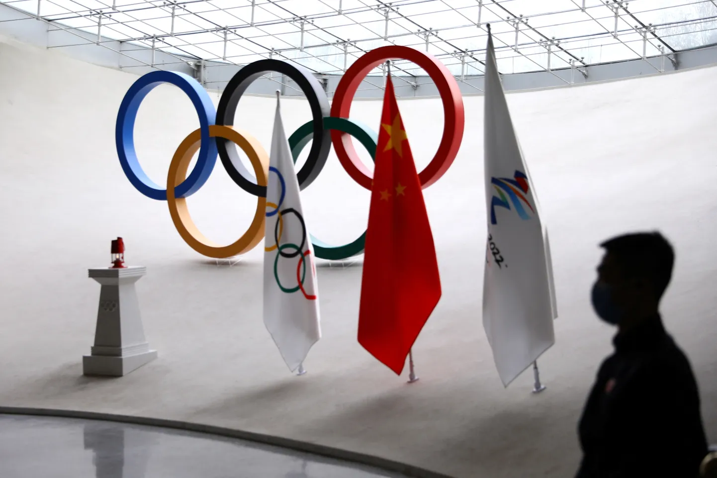 A staff member stands guard near a safety lantern carrying the Olympic flame of the Beijing 2022 Winter Olympics that is displayed inside the Olympic Tower, in Beijing, China December 10, 2021. REUTERS/Tingshu Wang