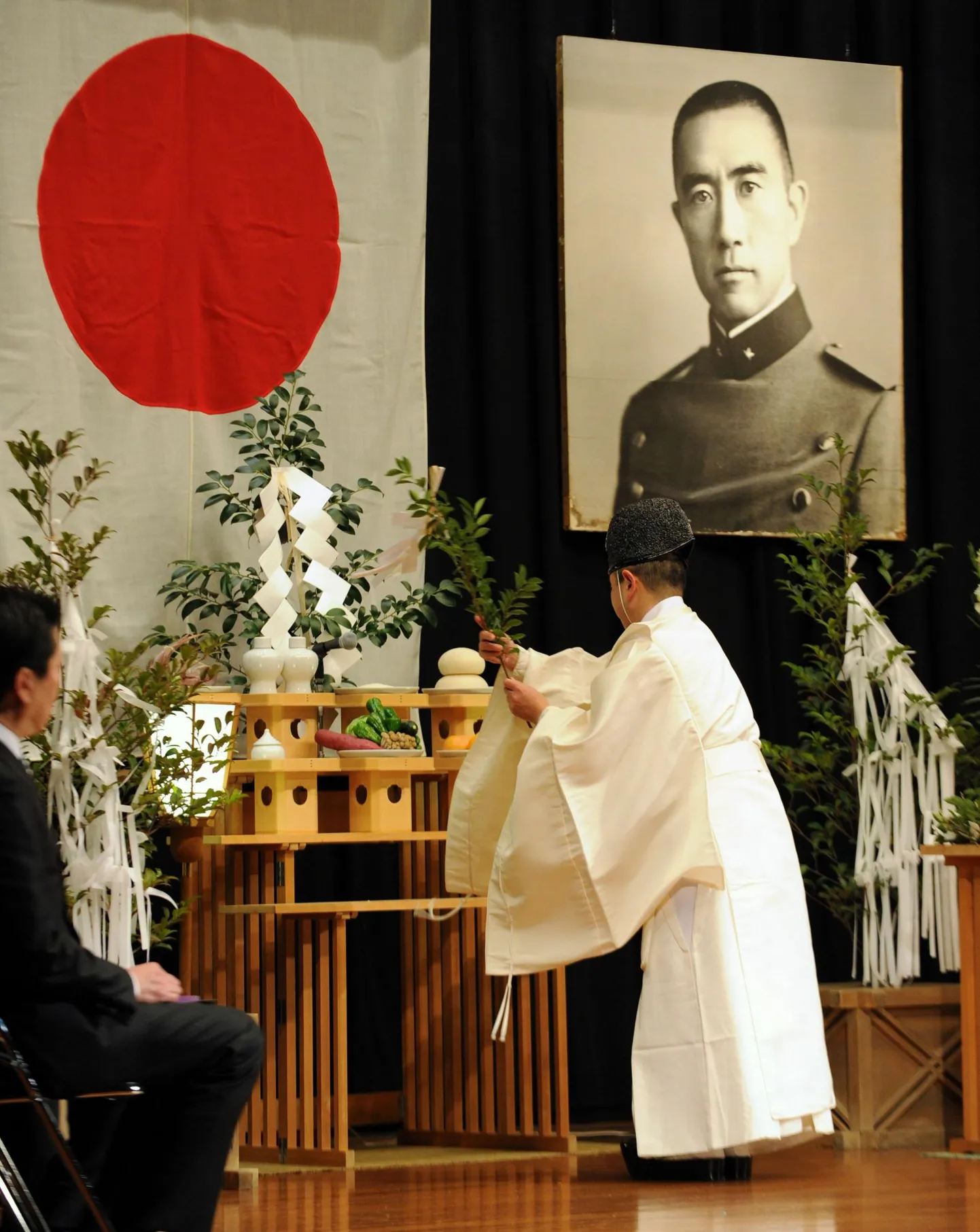 Shinto preester Mishima pildi kõrval tseremooniat pidamas.