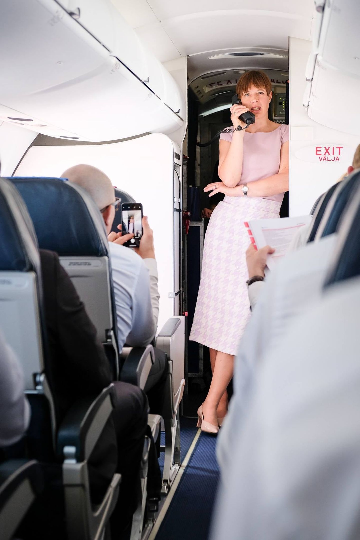 Керсти Кальюлайд говорит по телефону на борту самолета.