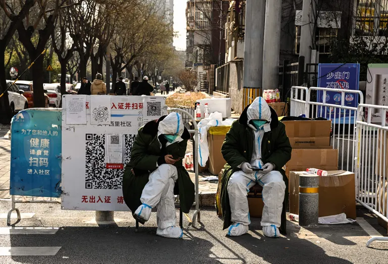 Охранники в защитных костюмах после отмены ограничительных мер по борьбе с коронавирусом 9 декабря 2022 года в Пекине.
