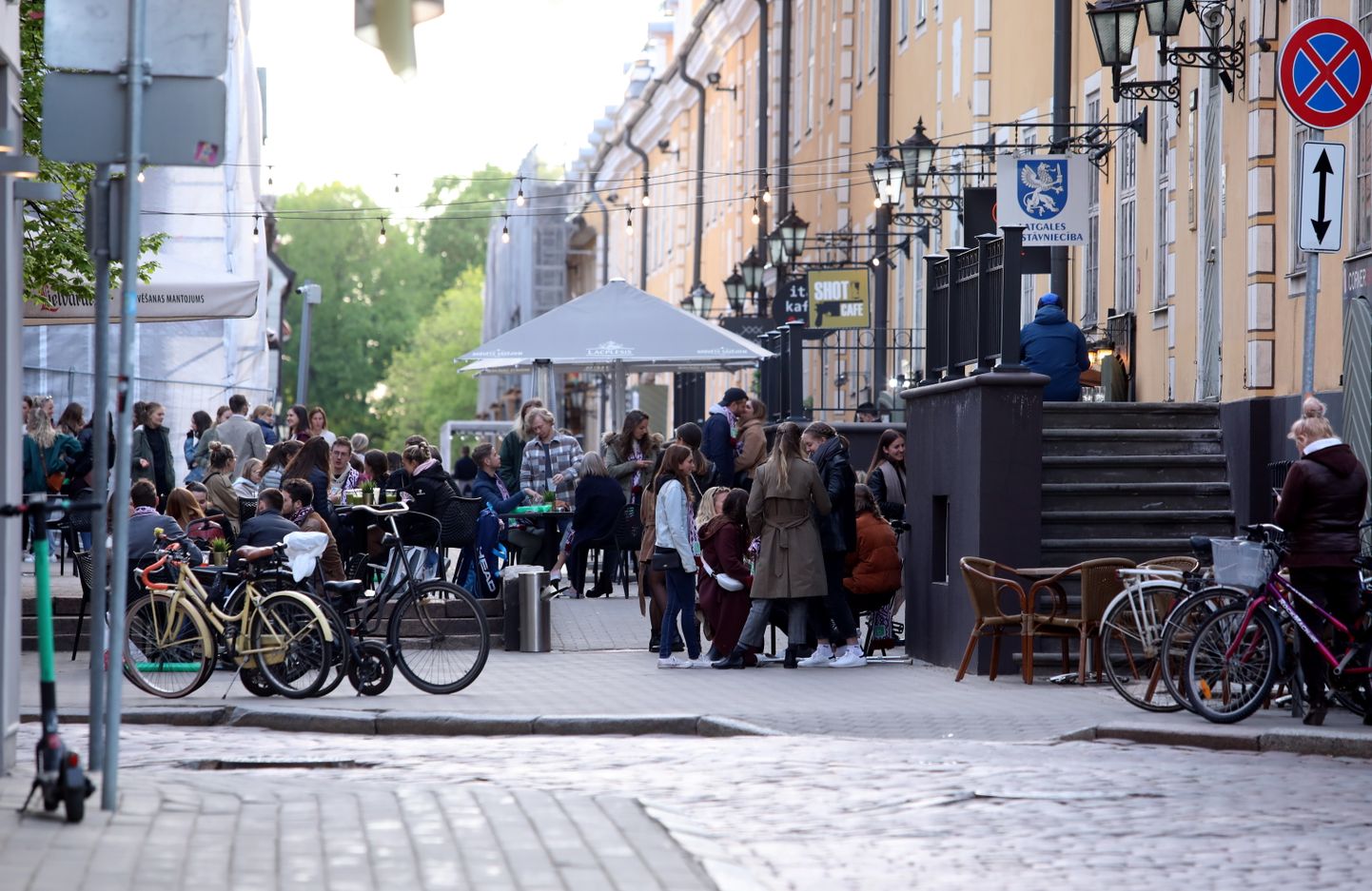 Cilvēki skatās Pasaules hokeja čempionāta spēli starp Latvijas un Kanādas valstsvienībām kafejnīcu vasaras terasēs Torņu ielā. Ilustratīvs attēls.