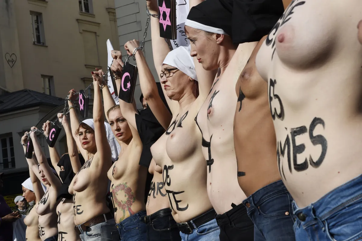 2015. gada 8. marts, Parīze, Francija. Feminisma kustības "Femen" aktīvistes Starptautiskajā sieviešu dienā rīko demonstrāciju, kuras laikā atkailinās un savstarpēji saslēdzas ar roku dzelžiem.
