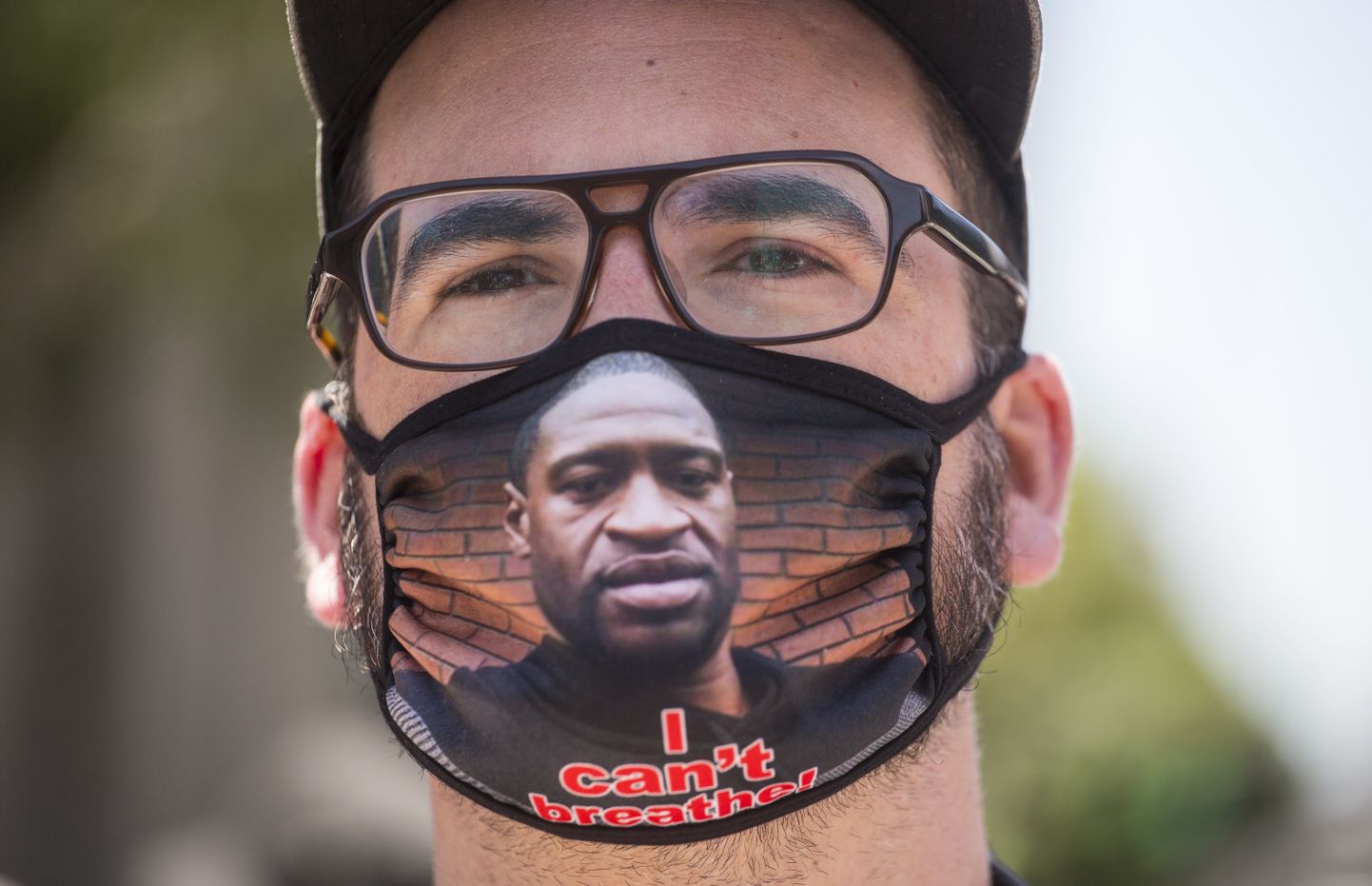 Valgenahaline mees kandmas näomaski, millel on afroameeriklase George Floydi näopilt ja tekst «Ma ei saa hingata»