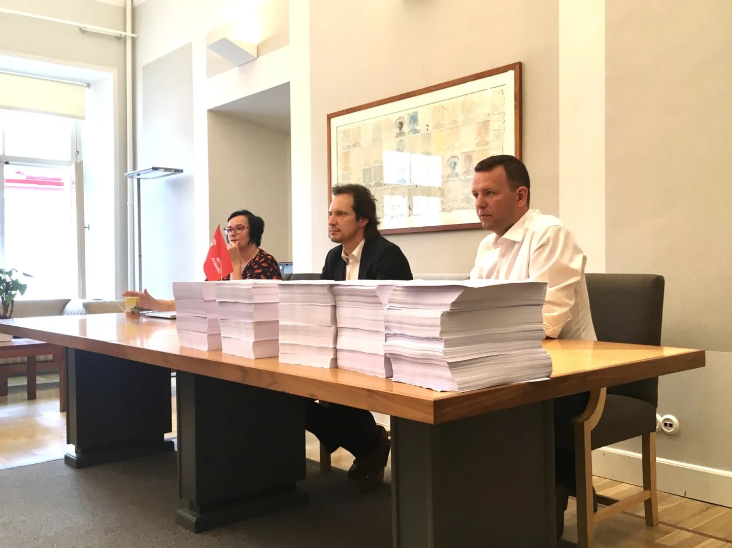 Katri Raik, Indrek Saar ja Lauri Läänemets tõid 50 000 muudatusettepaneku näitlikustamiseks lauale viis pabervirna.