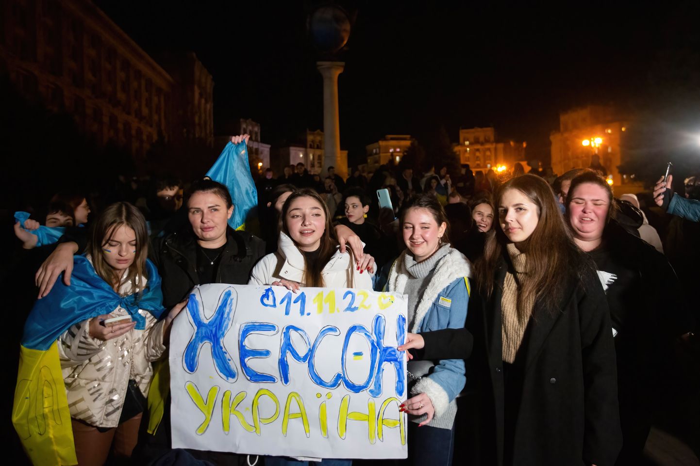 Inimesed tähistamas Kiievi kesklinnas Hersoni vabastamist lehvitades seejuures plakatit eilse kuupäevaga ja sõnumiga «Herson on Ukraina».