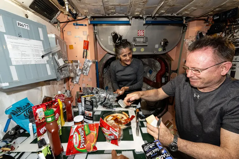 NASA astronaudid Suni Williams ja Butch Wilmore valmistavad pitsat Rahvusvahelise Kosmosejaama kambüüsis, demonstreerides mikrogravitatsioonis toiduvalmistamise oskusi.