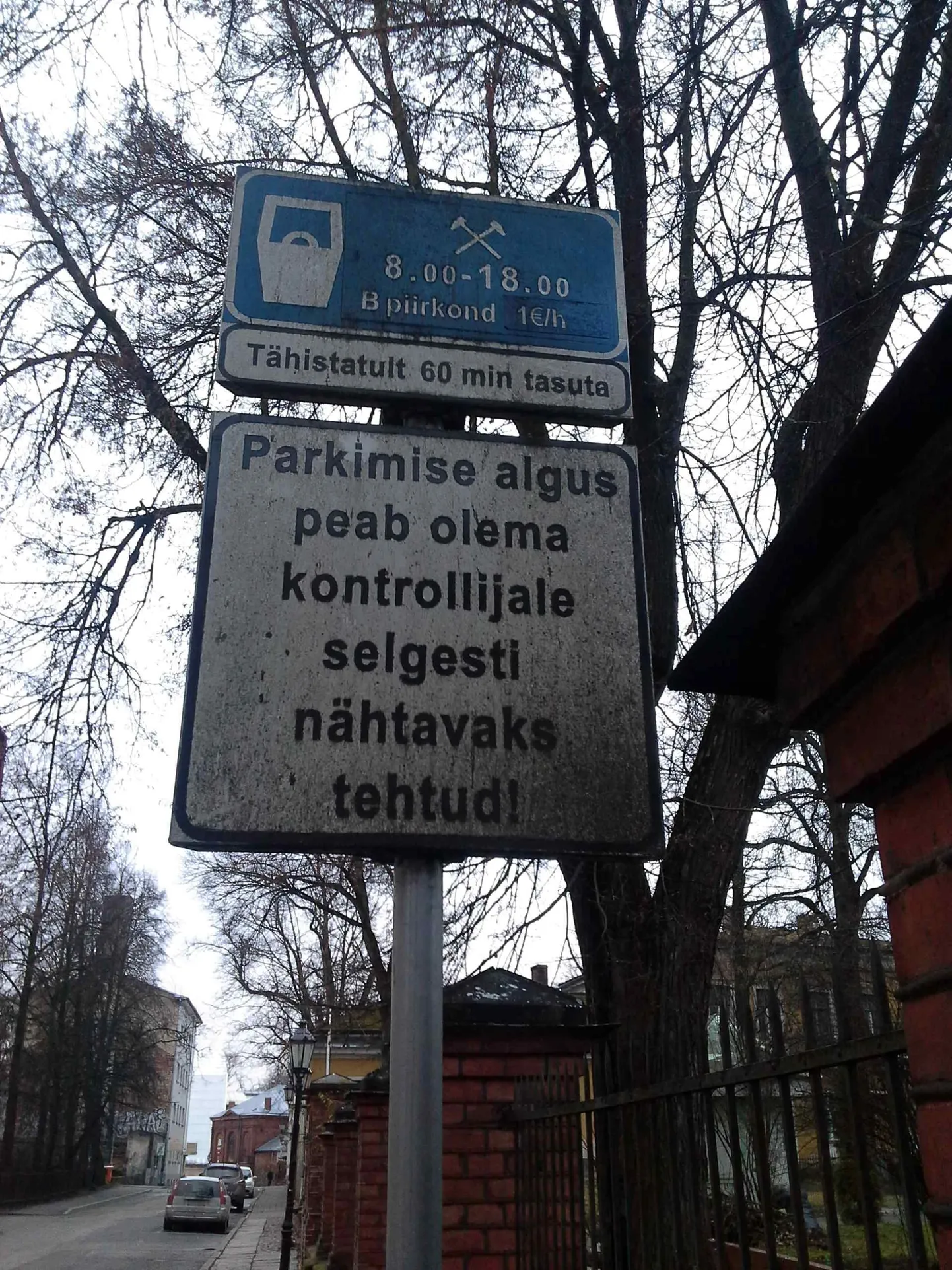 Parkimisel parkimiskella nähtavaks tegemist nõudev silt Magasini tänaval on sellele kasvanud sambla tõttu üsna kehvasti märgatav.