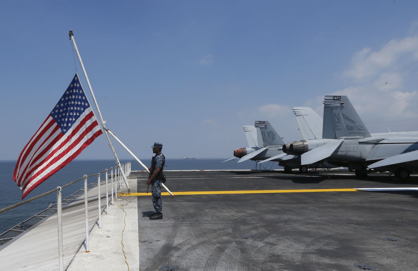A U.S. Marine stands guard on the flight deck of the USS Carl Vinson aircraft carrier anchors off Manila, Philippines, for a five-day port call along with guided-missile destroyer USS Michael Murphy, Saturday, Feb. 17, 2018. Lt. Cmdr. Tim Hawkins told The Associated Press that American forces will continue to patrol the South China Sea wherever international law allows when asked if China's newly built islands could restrain them in the disputed waters. (AP Photo/Bullit Marquez)