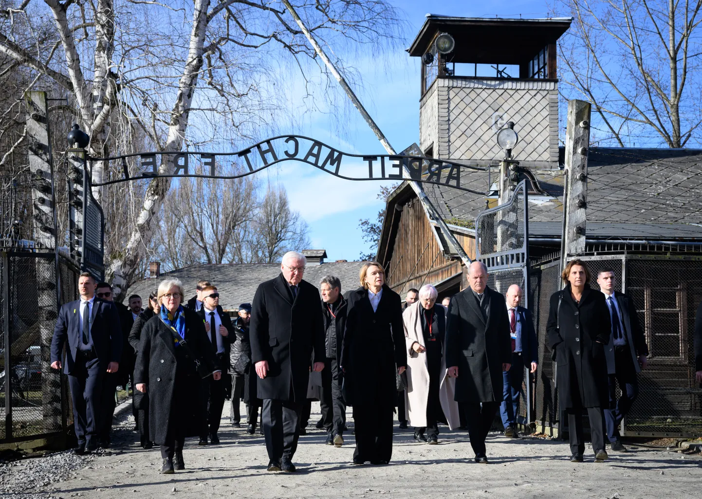 Saksamaa president Frank-Walter Steinmeier (paremalt neljas) koos kantsler Olaf Scholziga (paremalt teine) Auschwitz-Birkenau koonduslaagri väravate ees, 27. jaanuaril 2025. a.
