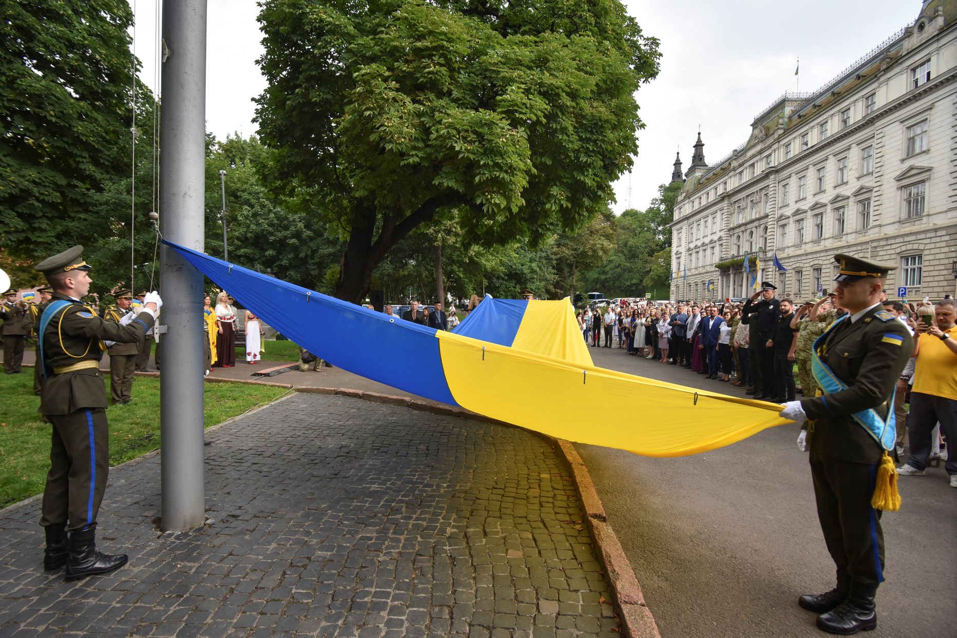 Военнослужащие Почетного караула поднимают Государственный флаг во время церемонии, посвященной Дню украинской государственности.