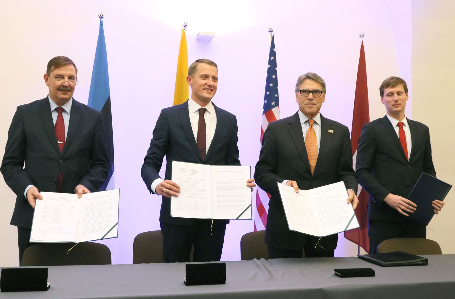 (L-R) Estonian Minister of Economy and Infrastructure Taavi Aas, Lithuanian Minister of Energy Zygimantas Vaiciunas, US Secretary of Energy Rick Perry and Latvian Minister of Economy Ralfs Nemiro shows documents after signing an agreement on strengthening energy cooperation between the US and the Baltic States during a meeting in Vilnius, Lithuania, on October 6, 2019. - The United States and Baltic states on October 6, 2019 agreed to beef up cooperation to protect the Baltic energy grid from cyber attacks as they disconnect from the Russian electricity grid. (Photo by Petras Malukas / AFP)