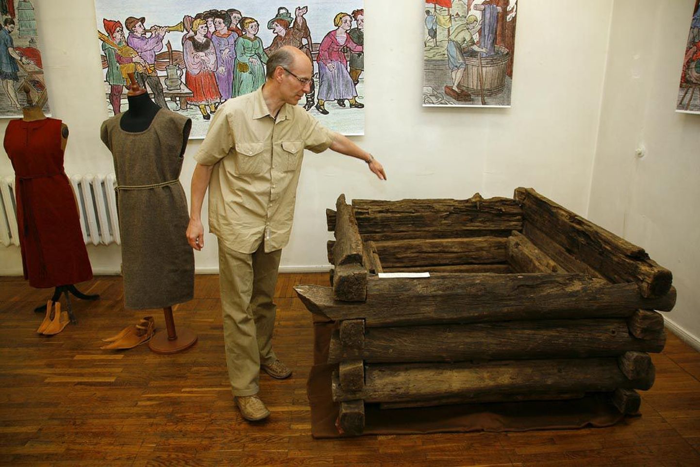 Pärnu muuseumi direktor Aldur Vunk tutvustab eksponaate, Munga tänavalt leitud 16.-17. sajandi haavapuust topeltsalvedega kaevu ja Parisselja raba rõivaleidu.