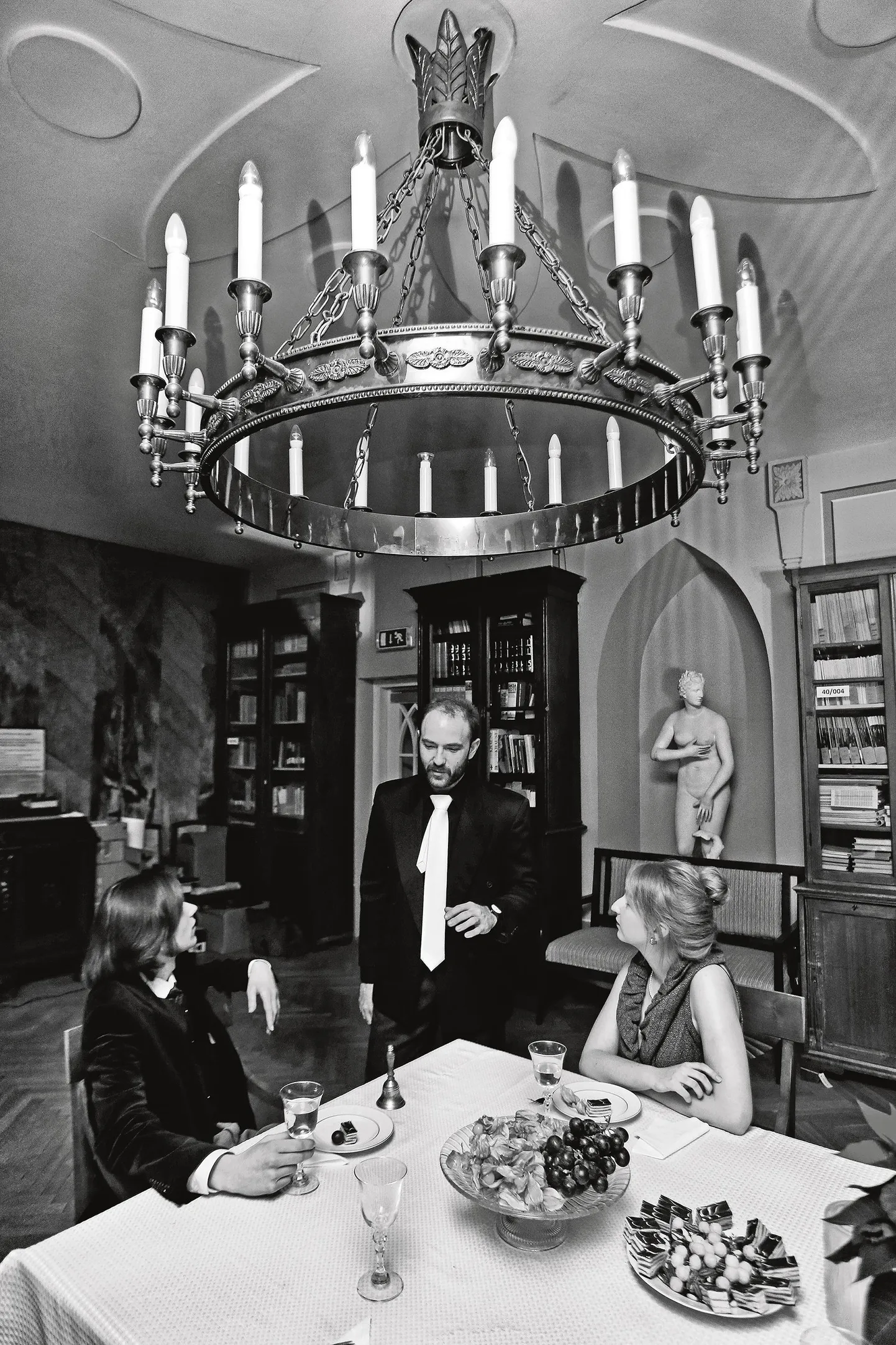 Laua ümber on Rolf (vasakult, Danel Ülper), pastor Roth (Henry Griin) ja Toto (Merilyn Elge), kes ootavad järjekordset vaatajat. Foto on toimetatud mustvalgeks, sest lavastuse «Hingede öö» kunstnike arvates toetavad mustvalged fotod ja videod, mille nad on ise teinud, lavastuse unenäolist maailma.