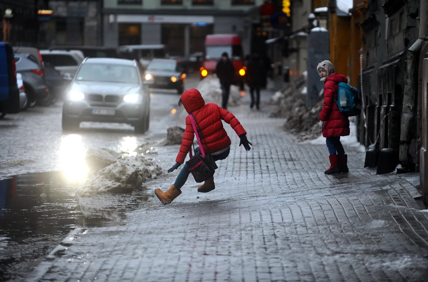 Krītoša meitene uz apledojušās Alfrēda Kalniņa ielas.