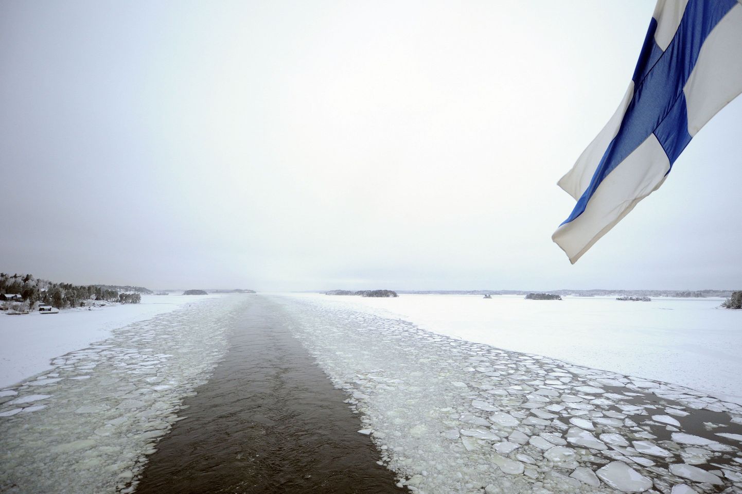 Soome lipu all sõitev laev talvisel merel.