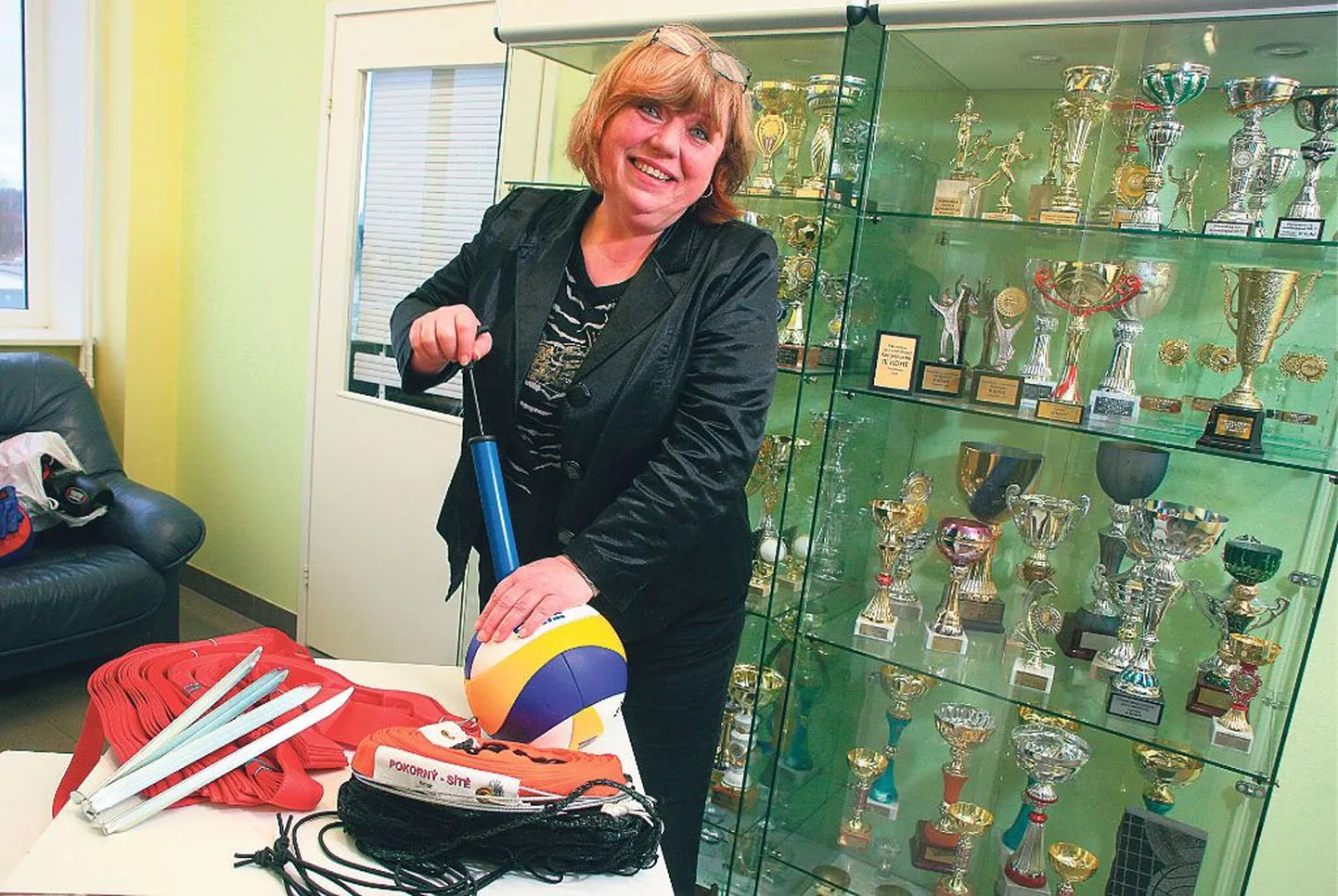 Sauga valla spordijuht Tiiu Alliksalu näitab sporditrofeedest pungil vitriini ees, et Rootsi eestlaste liidu rahalise abiga ostetud võrkpallivarustus on igati kulutust väärt. Pall peab õhku ning nüüd jääb üle oodata välishooaja algust.